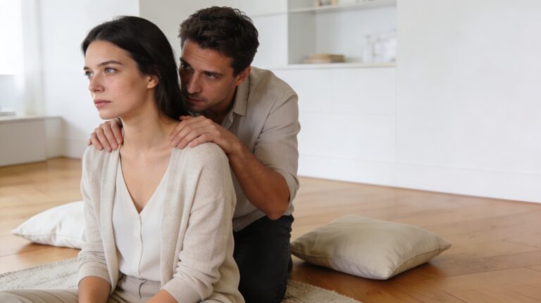 Une femme semble chercher de l’espace tandis qu’un homme reste très proche d’elle dans un intérieur contemporain, illustrant une relation étouffante.